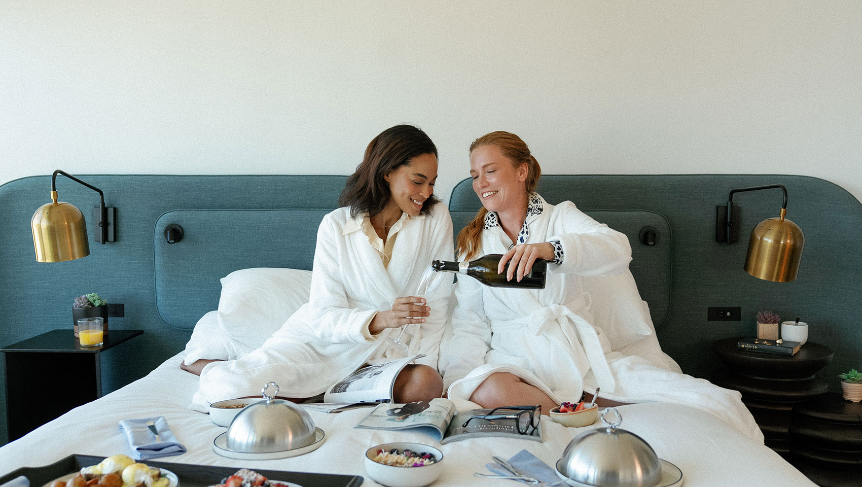 women in bed with room service