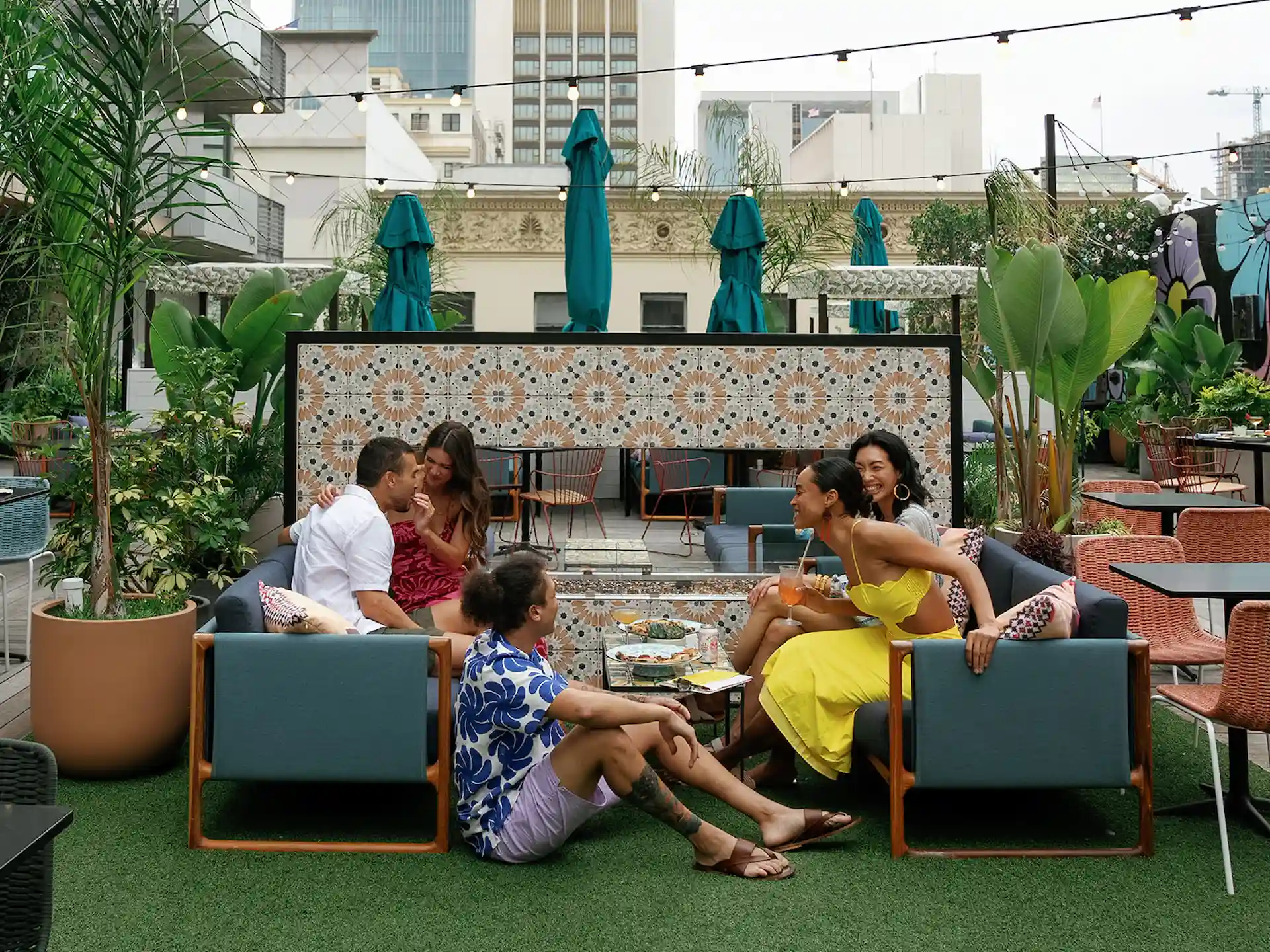 Group of friends sharing laughs on the terrace of the Leave of Absense, enjoying a lively and fun atmosphere