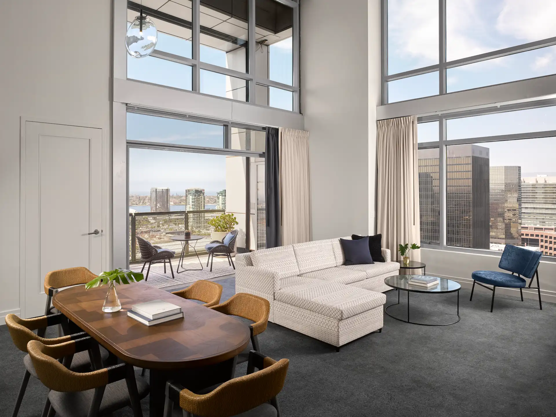 Living room and balcony of the Coronado Loft Suite, featuring large glass windows with stunning views