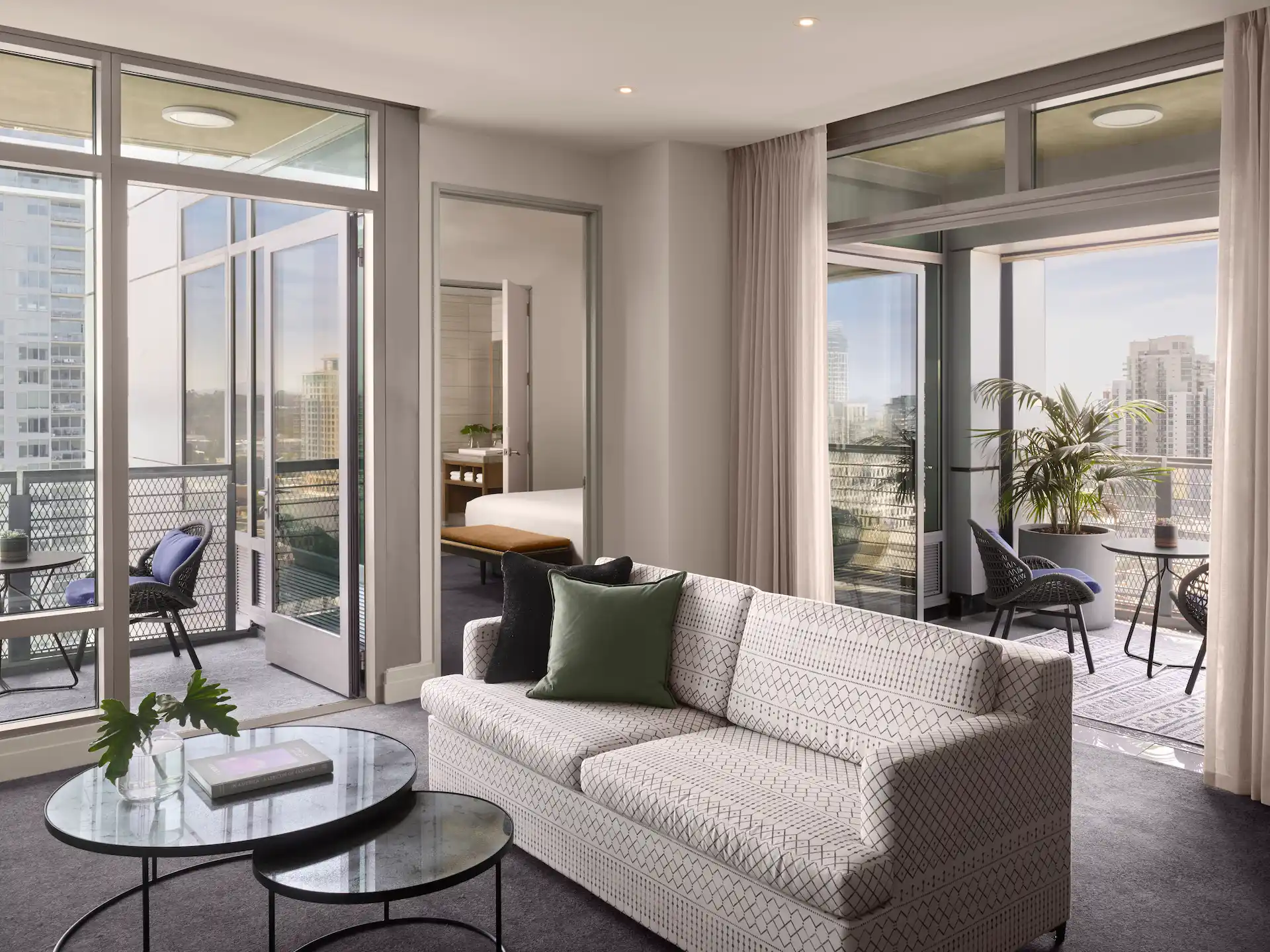 Living room and balcony of the 1 Bedroom Suite Harbor View Balcony, showcasing elegant decor and beautiful harbor views